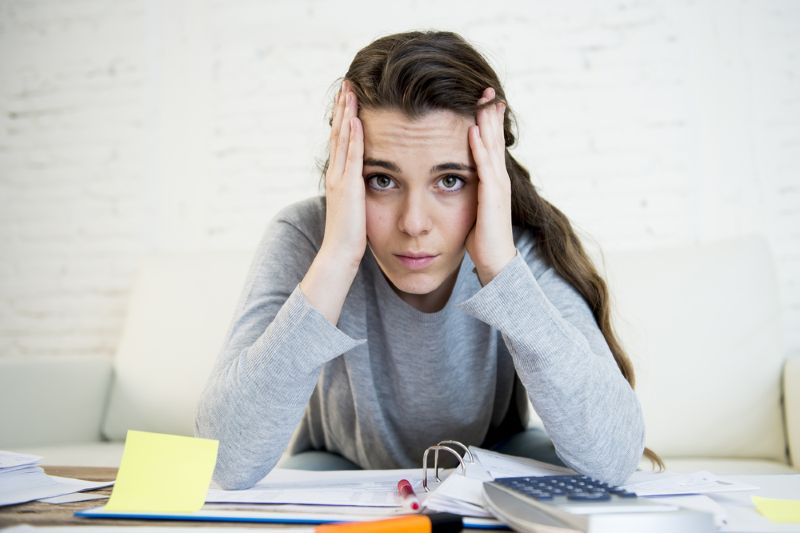 Woman stressed with overwhelming mound of paperwork