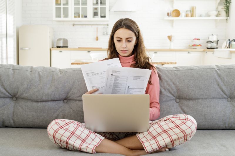 woman sitting on couch going over paperwork