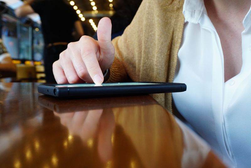 A woman scrolling on her phone in a coffee shop